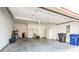 Spacious garage with concrete floor, storage shelves, trash cans, and a refrigerator at 2326 Saddle Dr, Shelbyville, IN 46176