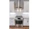 Stylish kitchen with stainless steel range hood and appliances, white cabinets, and subway tile backsplash at 2326 Saddle Dr, Shelbyville, IN 46176