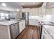 Modern kitchen with stainless steel appliances, white cabinets, and a granite island, flowing into the dining area at 2326 Saddle Dr, Shelbyville, IN 46176