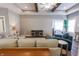 Open-concept living room features wood beams, ceiling fan, and comfortable seating arrangement at 2326 Saddle Dr, Shelbyville, IN 46176