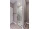 Tiled walk-in shower with glass doors and a built-in handrail. Stylish and accessible at 2326 Saddle Dr, Shelbyville, IN 46176