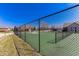 Community tennis court surrounded by a high fence, with trees and homes visible in the background at 2326 Saddle Dr, Shelbyville, IN 46176