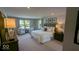 Spacious primary bedroom with a plush bed, sitting area by the window, and framed art at 2882 Simsbury Ln, Brownsburg, IN 46112