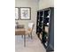 Neutral home office with a natural wood desk, cream chair, dark bookcase, and neutral walls and carpet at 2882 Simsbury Ln, Brownsburg, IN 46112