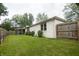 Well-maintained backyard features a manicured lawn, mature trees, and a charming screened-in porch for outdoor enjoyment at 3335 Woodcrest Ct, Columbus, IN 47203