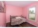 Bright bedroom featuring pink walls, wood floors, artwork, and a comfortable day bed by a window with outside views at 3335 Woodcrest Ct, Columbus, IN 47203