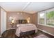 Cozy bedroom with large bed, side table, bedside lamps, and a window with view of the neighborhood at 3335 Woodcrest Ct, Columbus, IN 47203