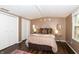 Cozy bedroom with large bed, side table, bedside lamps, and a window with view of the neighborhood at 3335 Woodcrest Ct, Columbus, IN 47203