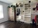 Walk-in closet featuring custom shelving, a rolling chair, and hardwood floors at 3335 Woodcrest Ct, Columbus, IN 47203