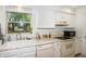 Cozy kitchen showcasing white cabinets, stainless steel sink, and a bright window view at 3335 Woodcrest Ct, Columbus, IN 47203