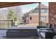 Covered deck featuring a hot tub and cozy seating, with scenic views of the landscaped backyard and neighboring community at 4140 Sagewood Ct, Greenwood, IN 46143