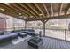 Spacious covered deck featuring comfortable seating, a fire pit, and backyard views of the landscaped neighborhood at 4140 Sagewood Ct, Greenwood, IN 46143