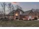 Exterior twilight shot of the home, highlighting elegant design elements and manicured landscaping at 4140 Sagewood Ct, Greenwood, IN 46143