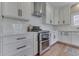 Close-up of a stainless steel stove and white backsplash against the bright countertops and white cabinets at 4140 Sagewood Ct, Greenwood, IN 46143