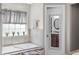 Bathroom view featuring a soaking tub, tiled surround, and stylish fixtures and mirror at 4347 Westminster Pl, Columbus, IN 47201