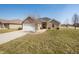 Charming single-story home boasts stone accents, a two-car garage, and a well-manicured front yard at 4347 Westminster Pl, Columbus, IN 47201