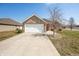 Lovely home with a brick facade, double garage door, concrete driveway, and manicured lawn at 4347 Westminster Pl, Columbus, IN 47201
