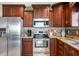 Modern kitchen featuring stainless steel appliances, dark wood cabinets, and granite countertops at 4347 Westminster Pl, Columbus, IN 47201