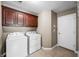 Functional laundry room with washer, dryer, cabinets, and door to adjacent space at 4347 Westminster Pl, Columbus, IN 47201