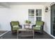 Back patio with green cushions and black wicker furniture at 4347 Westminster Pl, Columbus, IN 47201