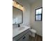 Modern bathroom features a gray vanity with white countertop, decorative lighting, and a framed mirror at 457 Mariposa Trl, Carmel, IN 46032