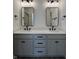 Modern bathroom features a gray double vanity with white countertop, modern lighting, framed mirrors, and hardwood floor at 457 Mariposa Trl, Carmel, IN 46032