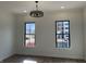 Modern bedroom features two windows and a decorative light fixture with hardwood floors, and light walls at 457 Mariposa Trl, Carmel, IN 46032