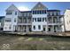 New construction exterior featuring multiple townhomes each with balconies, black shutters and fresh landscaping at 457 Mariposa Trl, Carmel, IN 46032