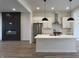 Modern kitchen features an island with sink, stainless appliances, and a view into an adjacent living space at 457 Mariposa Trl, Carmel, IN 46032
