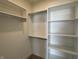 Well-organized walk-in closet with built-in shelving and hanging rods for storage and organization at 457 Mariposa Trl, Carmel, IN 46032