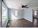 Spacious bedroom features a ceiling fan, three windows offering natural light, and wood-look flooring at 611 Della Rd, Columbus, IN 47203