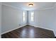 Well-lit bedroom has dark wood-look flooring and two windows providing plenty of natural light at 611 Della Rd, Columbus, IN 47203