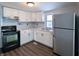 Kitchen with stainless steel appliances, white cabinets, and hard surface counter tops at 611 Della Rd, Columbus, IN 47203