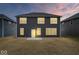 Backyard with dark siding, windows, and a lawn, set against a colorful dusk sky at 6724 Seattle Slew Dr, Whitestown, IN 46075