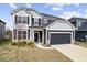 Two-story home featuring gray siding, black shutters, well-manicured lawn, and a two-car garage at 6724 Seattle Slew Dr, Whitestown, IN 46075