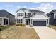 Two-story home featuring gray siding, black shutters, well-manicured lawn, and a two-car garage at 6724 Seattle Slew Dr, Whitestown, IN 46075