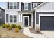 Close-up of a home's front door with stone accents and manicured landscaping at 6724 Seattle Slew Dr, Whitestown, IN 46075