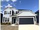 Beautiful two-story home with blue siding, black shutters, and attached two-car garage under a clear blue sky at 6724 Seattle Slew Dr, Whitestown, IN 46075