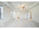 Large main bedroom with plush carpeting, tray ceilings, and multiple windows at 6724 Seattle Slew Dr, Whitestown, IN 46075