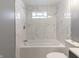 Bathroom features white marble-style tiled walls, and tub with shower at 7252 E 47Th St, Indianapolis, IN 46226