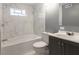 Bathroom features white marble-style tiled walls, gray vanity and tub with shower at 7252 E 47Th St, Indianapolis, IN 46226