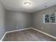 Bedroom features neutral grey walls, wood-look flooring, and a bright window at 7252 E 47Th St, Indianapolis, IN 46226