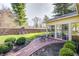 Lovely brick patio featuring outdoor seating and a sunroom, all surrounded by mature trees and lush greenery at 7943 Beaumont Green East Dr, Indianapolis, IN 46250