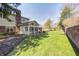 Spacious backyard with brick patio, sunroom, and mature trees, creating a serene and private oasis at 7943 Beaumont Green East Dr, Indianapolis, IN 46250