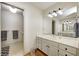 Bathroom with double vanity sink, large mirror, neutral walls, and hardwood floors at 7943 Beaumont Green East Dr, Indianapolis, IN 46250