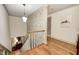 A staircase and hallway featuring hardwood floors, neutral walls, and a charming light fixture at 7943 Beaumont Green East Dr, Indianapolis, IN 46250