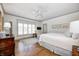 Comfortable main bedroom boasts natural light, hardwood floors, and a seating area at 7943 Beaumont Green East Dr, Indianapolis, IN 46250