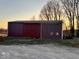 Large, well-maintained barn with a sliding door, ideal for storage or livestock housing on the property at 8089 W Old State Road 67, Paragon, IN 46166