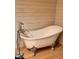 Bathroom with clawfoot tub and chrome faucet fixtures set against wooden paneling at 8089 W Old State Road 67, Paragon, IN 46166