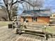 Brick cottage on wood deck features swing bench and adjacent table with decor at 810 S 400 W, Bargersville, IN 46106